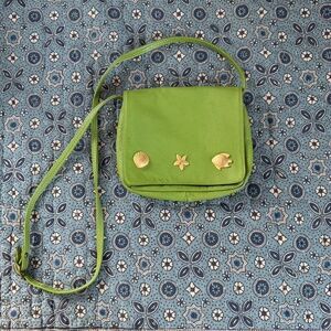 Green small leather shoulder bag with gold fish and seashell charms